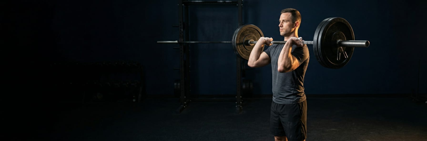 Barbell on gym floor with training journal and pen, chalk dust atmosphere